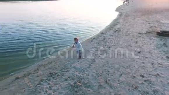 一个小女孩从沙滩上跑下来跳进了她妈妈的肚子视频的预览图