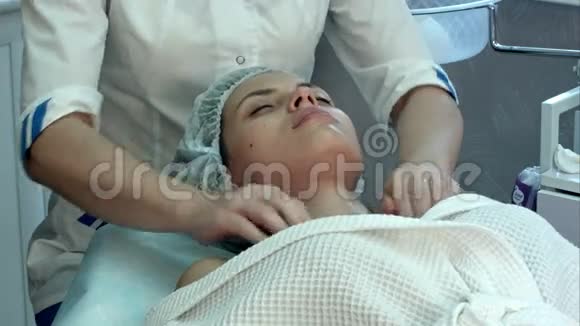 在水疗中心做面部和颈部按摩的年轻女性视频的预览图