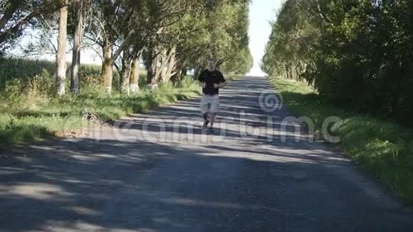 在森林小路上户外跑步的成年男子在大自然中慢跑的老人视频的预览图