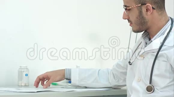 戴眼镜的年轻医生向病人展示医疗结果视频的预览图