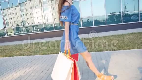 年轻女子背着购物袋走在街上视频的预览图