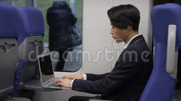 在火车上韩国商人正在用笔记本电脑工作视频的预览图