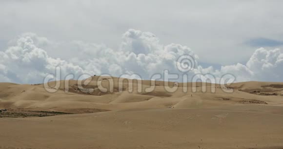 在沙漠沙丘上翻滚的4k时间推移的白色蓬松的大云团视频的预览图
