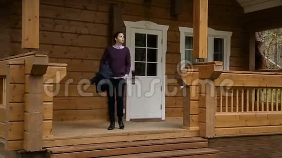 一个穿着紫色毛衣和衬衫的黑发女孩走下楼梯视频的预览图