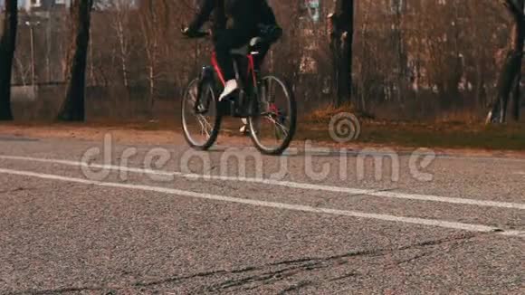骑着一辆红色自行车的自行车步行在人行道上视频的预览图