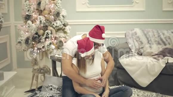 丈夫和他怀孕的妻子庆祝圣诞节和新年视频的预览图