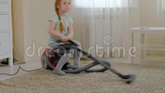 一个金发的小女孩坐在吸尘器上打扫卫生带来秩序和清洁帮助妈妈视频的预览图