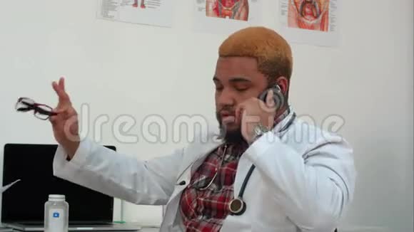 非裔美国男医生打电话让病人等待视频的预览图