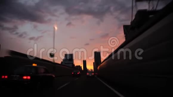 风盾玻璃第一人称波夫大灰雨云令人叹为观止的黄昏夕阳天空繁忙的交通公路道路视频的预览图