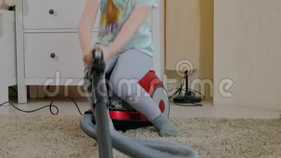 一个金发的小女孩坐在吸尘器上打扫卫生带来秩序和清洁帮助妈妈视频的预览图
