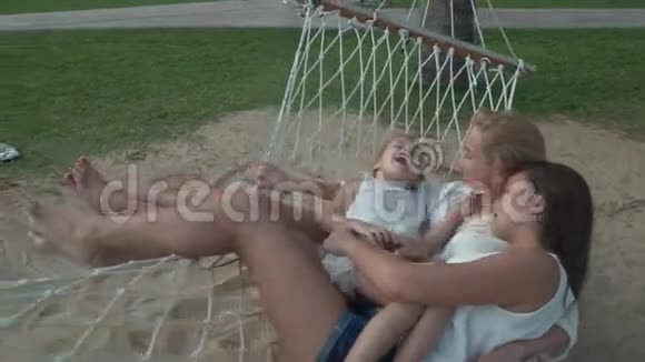 快乐的母亲和女儿一起摇摆吊床慢动作股票录像视频的预览图