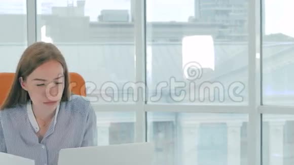 一个非常疲惫工作过度的年轻女士在办公室里视频的预览图