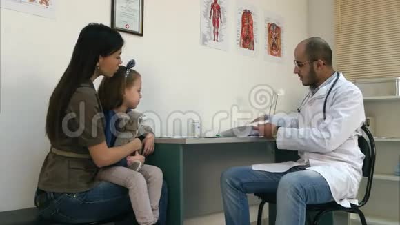 微笑医生向妈妈和小女孩解释心脏造影视频的预览图