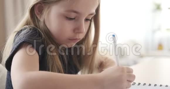 可爱的女孩用钢笔写作视频的预览图