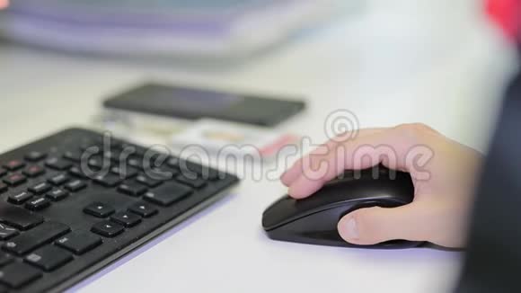 黑鼠上雌手特写女人用无绳鼠标在白色桌子上把手的肖像贴紧视频的预览图