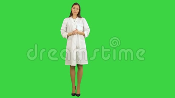 穿着实验室制服的严肃的年轻女人在绿色屏幕上和摄像机说话Chroma键视频的预览图