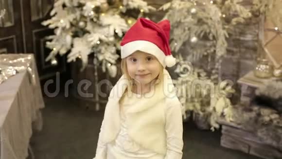 一个漂亮的小女孩摘下圣诞老人的帽子视频的预览图