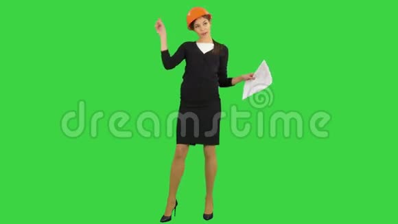 女工程师戴着头盔拿着文件在绿色屏幕上跳着滑稽的舞蹈Chroma键视频的预览图