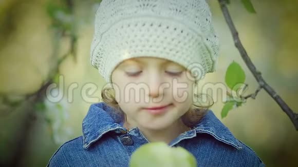 公园里吃绿苹果的小女孩的肖像视频的预览图