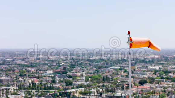 城市景观背景风向指示器风筒在直升机降落地点附近移动橙色视频的预览图