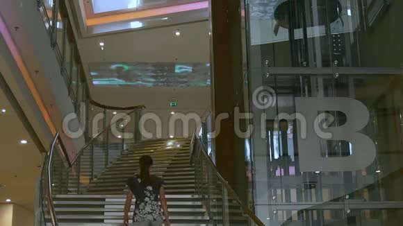 年轻女子走在现代建筑的楼上视频的预览图
