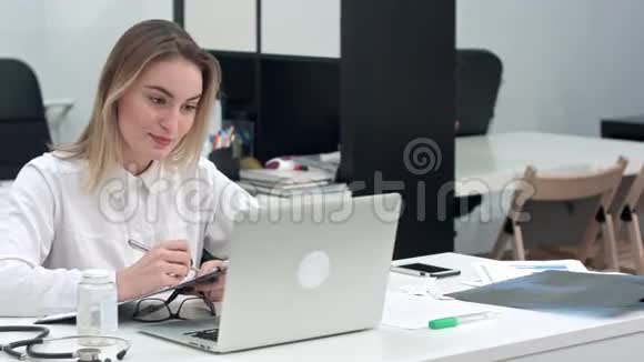 女医务工作者展示如何通过笔记本电脑视频通话检查手腕脉搏视频的预览图