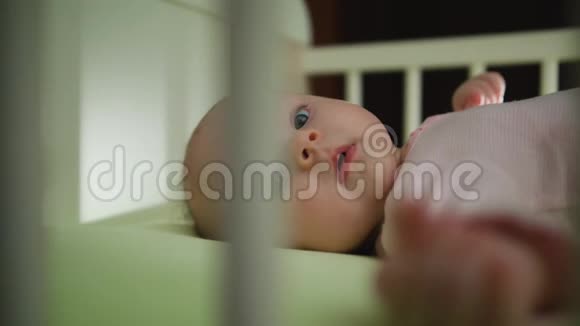 小宝宝躺在婴儿床上的动作视频的预览图