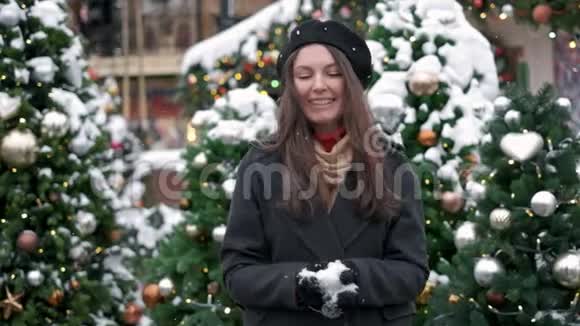 美丽的冬天女孩在市中心吹雪户外飞翔的雪花快乐的年轻女人有乐趣冬季和视频的预览图