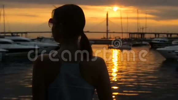 夏天日落的时候女孩戴着太阳镜回来视频的预览图
