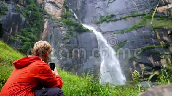 在印度的马纳利少年用智能手机拍摄著名的乔吉尼瀑布视频的预览图