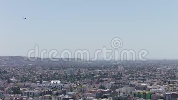 直升机飞越洛杉矶比佛利山地区轻型直升机接近着陆直升机对角下视频的预览图