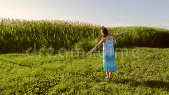 日落时分年轻的少女在草地上跳舞视频的预览图