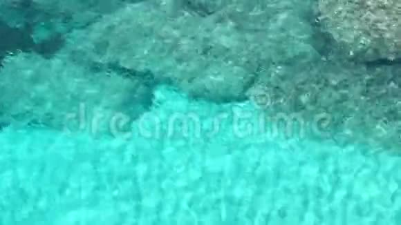 通过晶莹清澈的蓝色海水在海面和海底看到美丽的绿松石波纹视频的预览图