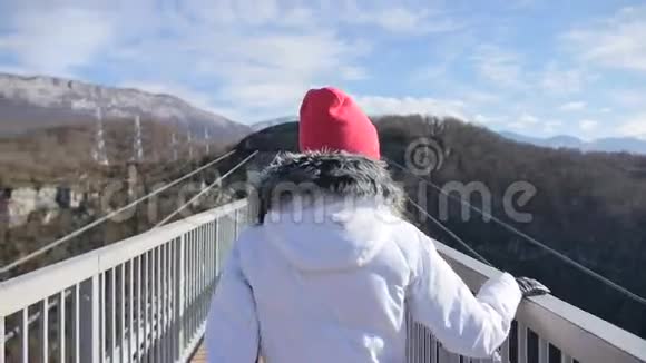 女人在天空公园AJHackettSochi的峡谷上通过高桥行走视频的预览图