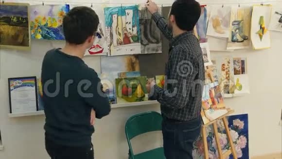 两个年轻人在艺术工作室看绘画视频的预览图