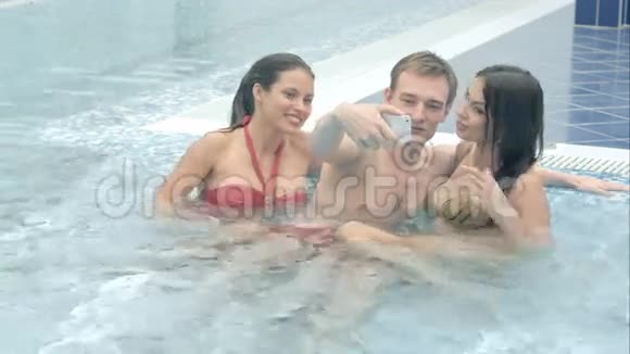 两个美女和一个年轻人在游泳池里自拍视频的预览图