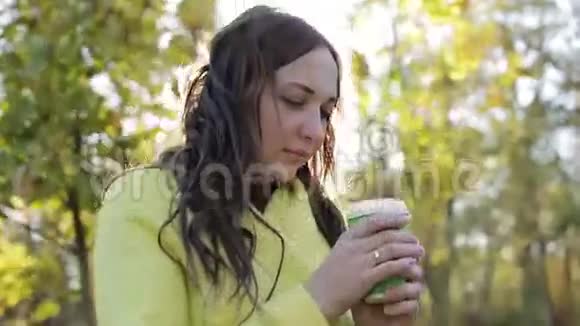 长发的年轻女子在秋天喝茶视频的预览图