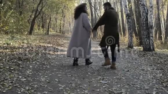 拥抱情侣在秋天公园散步视频的预览图