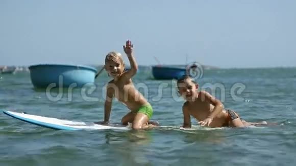 玩冲浪的小孩子们慢动作地挥舞着手视频的预览图