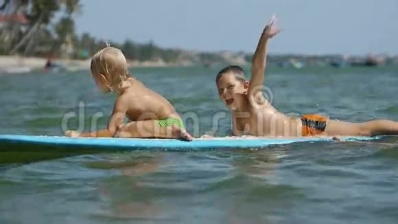 玩冲浪的小孩子们慢动作地挥舞着手视频的预览图