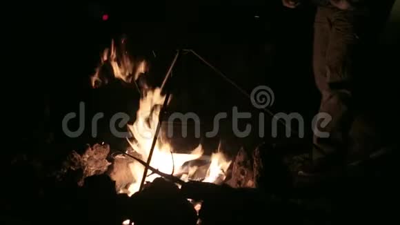 夜间篝火晚餐是在明火上用锅煮的视频的预览图