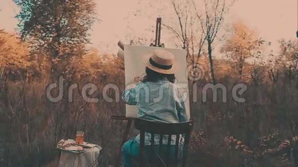 年轻的艺术家画一幅秋天的风景画艺术家绘画本质上的女孩视频的预览图
