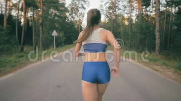 把慢跑鞋和慢跑者的腿收起来一名女运动员在公园路外训练的背面视频的预览图