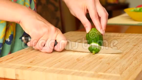 女人用刀子在木板上刻了一根黄瓜4k慢动作视频的预览图