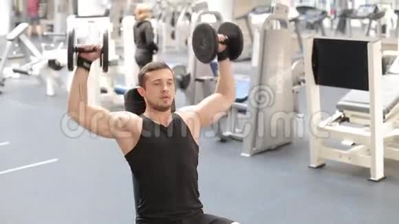 健美运动员在健身房用哑铃进行锻炼视频的预览图