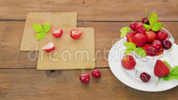 放在木桌上的白色盘子上是草莓和樱桃视频的预览图