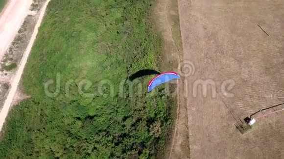 空中观景台滑翔伞飞越海岸线滑翔伞的翅膀被风吹动一排大海和视频的预览图