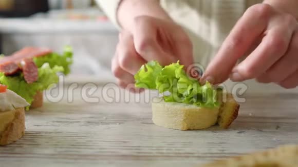 女人用沙拉叶做三明治摊开樱桃番茄视频的预览图