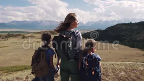 旅途中的游客家属在竞选中有两个女儿的母亲带背包的孩子们欣赏视频的预览图