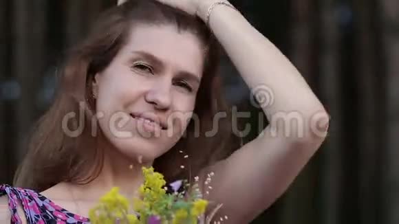 美丽的灵感女人拿着一束野花视频的预览图
